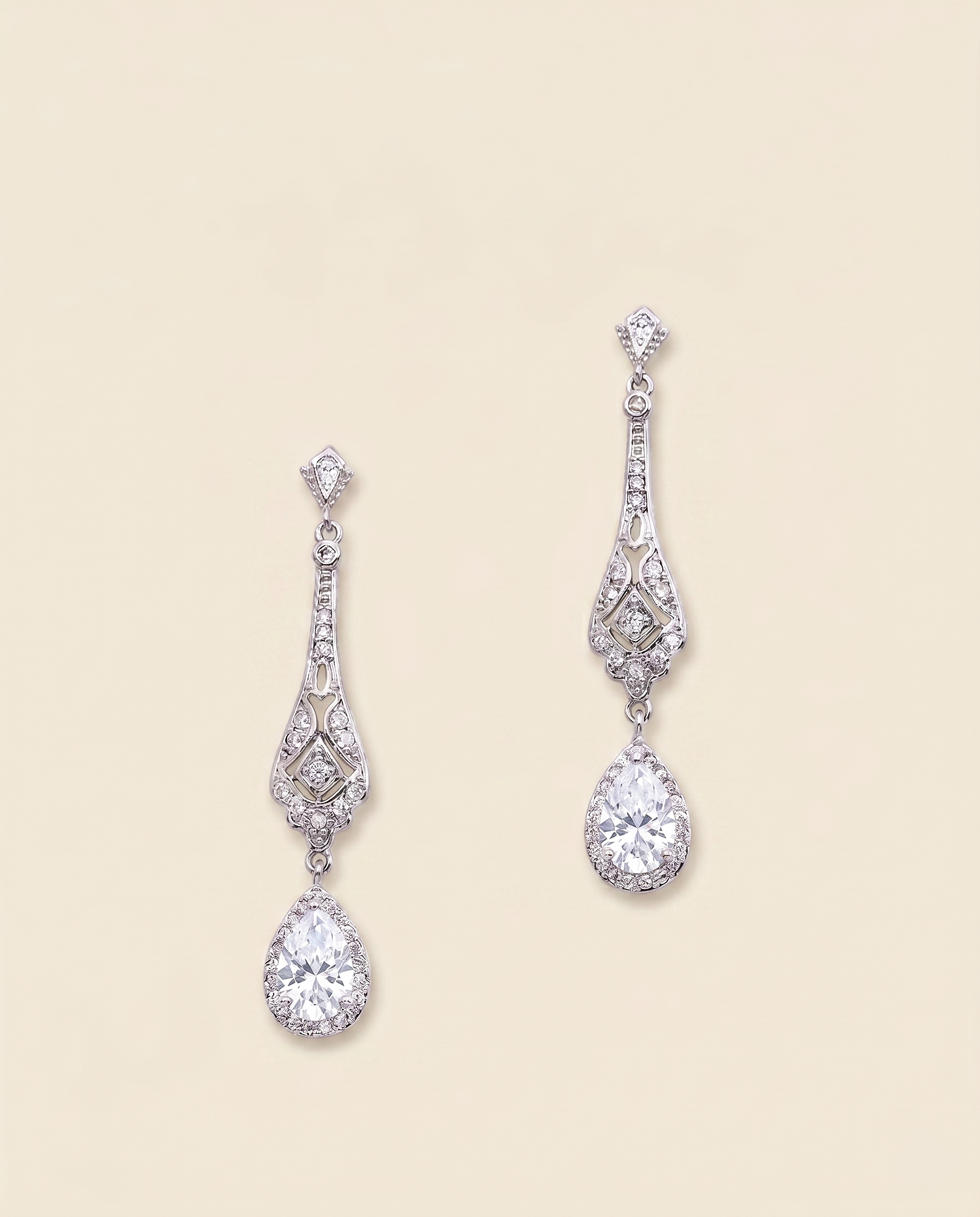 A pair of elegant diamond earrings with intricate designs and dangling crystal stones.