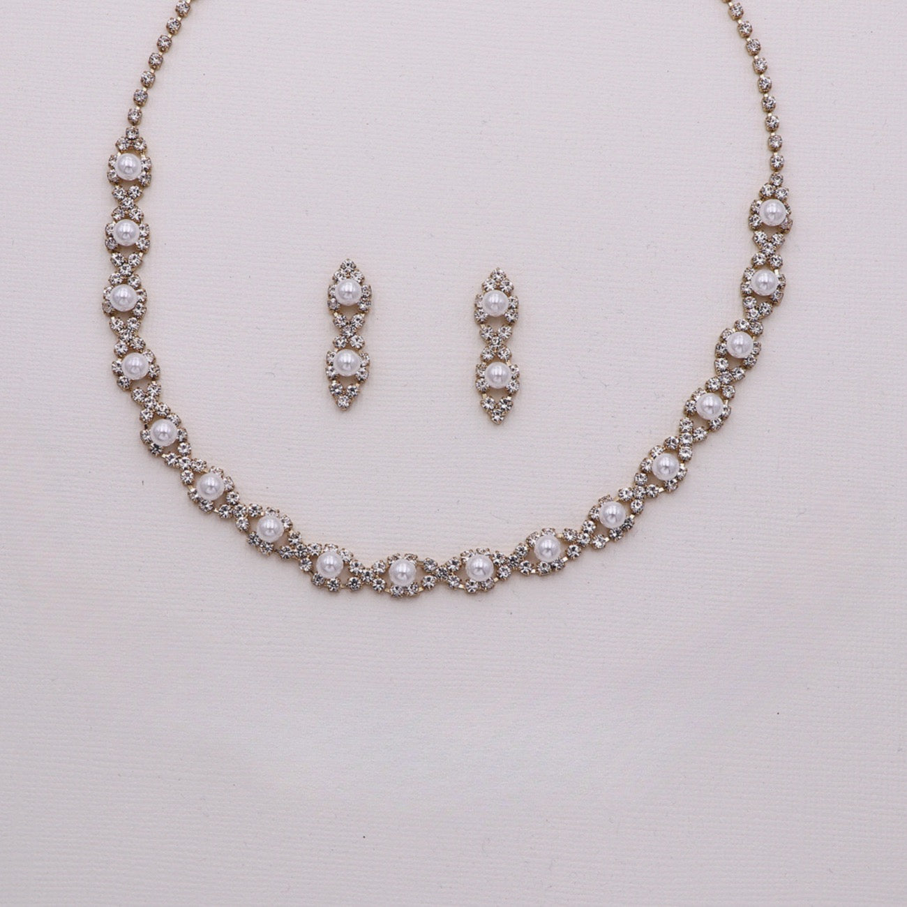 A necklace and earrings set made of sparkling rhinestones and pearls.