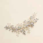 A decorative hair accessory made of silver and crystal elements, including branches and leaves with small pearls.