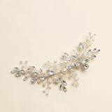 A decorative hair accessory made of silver and crystal elements, including branches and leaves with small pearls.