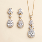 A set of elegant gold jewelry pieces, including earrings and a necklace, adorned with large, sparkling diamonds.