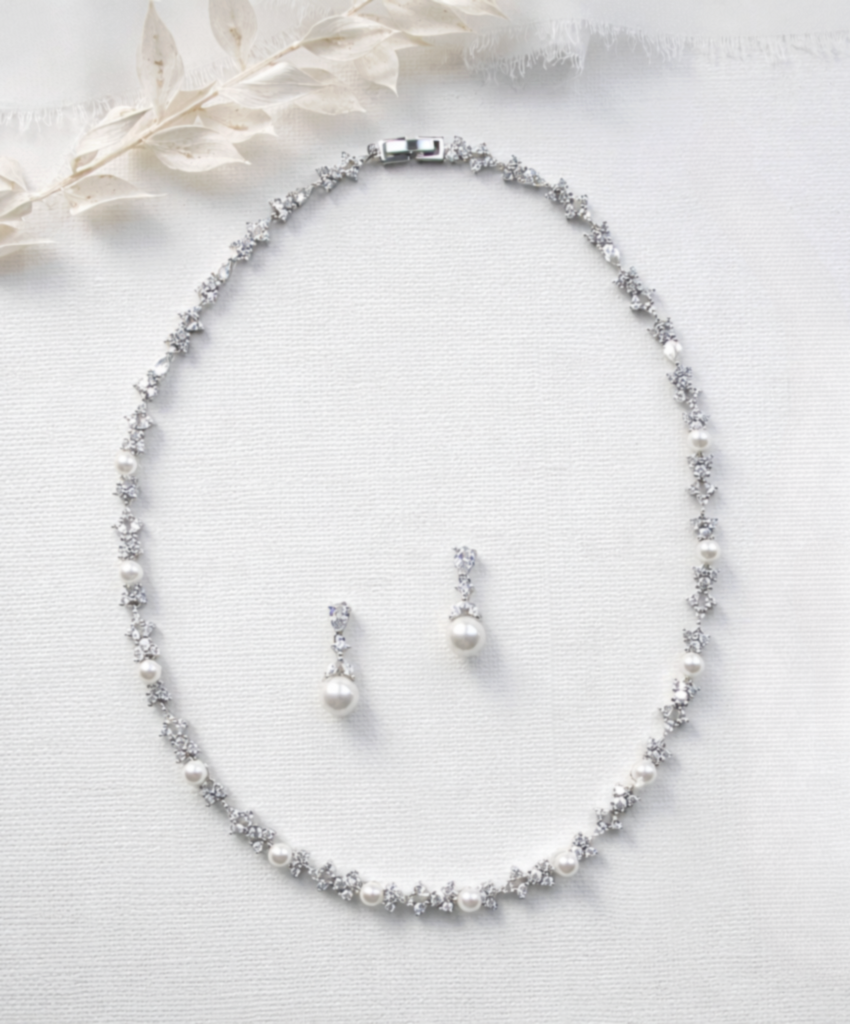 A necklace and earrings are displayed on a white background.