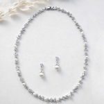 A necklace and earrings are displayed on a white background.