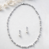 A necklace and earrings are displayed on a white background.