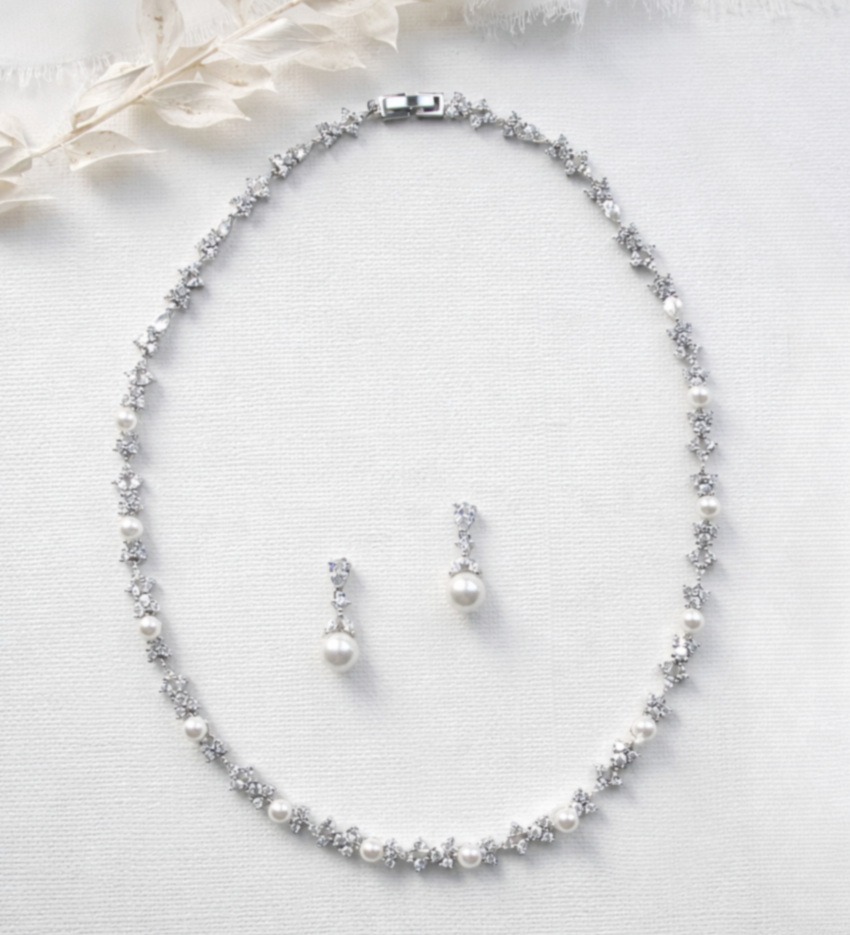 A necklace and earrings are displayed on a white background.