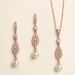 a set of elegant jewelry pieces, including earrings and a necklace, featuring a combination of pearls and diamonds.