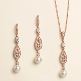 a set of elegant jewelry pieces, including earrings and a necklace, featuring a combination of pearls and diamonds.