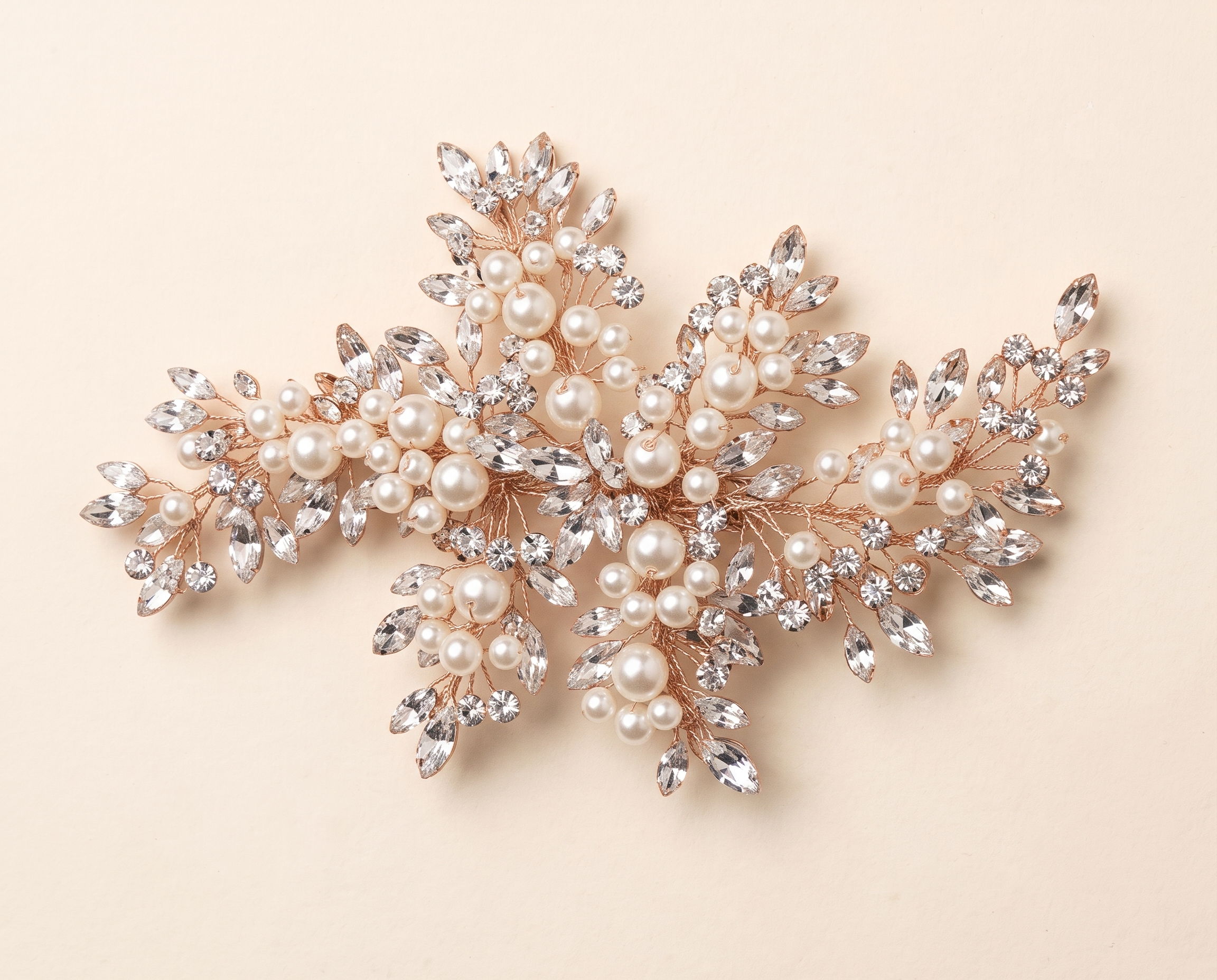 a decorative piece of jewelry with a combination of pearls, crystals, and leaves.