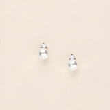 a pair of pearl earrings on a white background