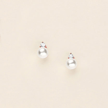 a pair of pearl earrings on a white background