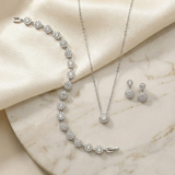 A necklace, earrings, and a bracelet are displayed on a marble surface, showcasing a collection of elegant jewelry pieces.