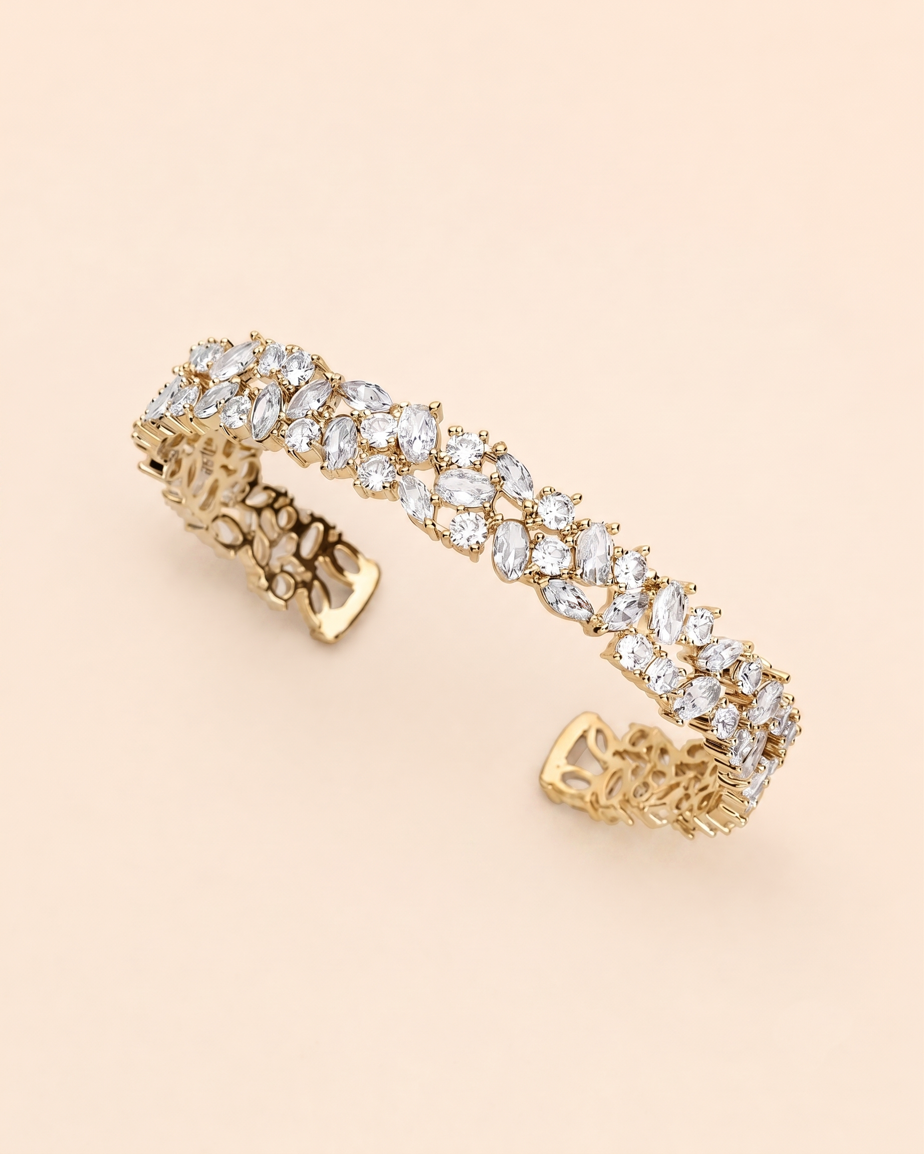 A gold bracelet adorned with numerous small, clear gemstones, including diamonds, set in a decorative pattern.