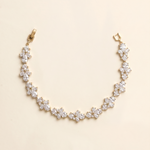 A delicate gold necklace with a row of small, clear gemstone pendants.
