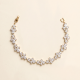 A delicate gold necklace with a row of small, clear gemstone pendants.