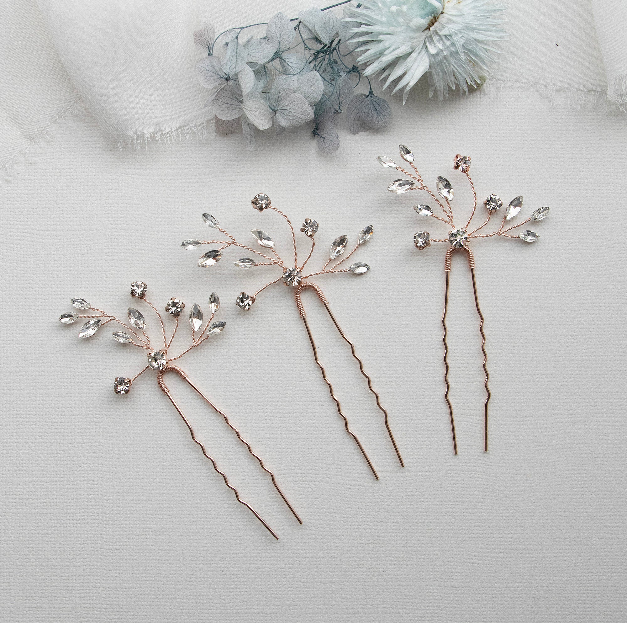 three different types of hair pins on a white surface