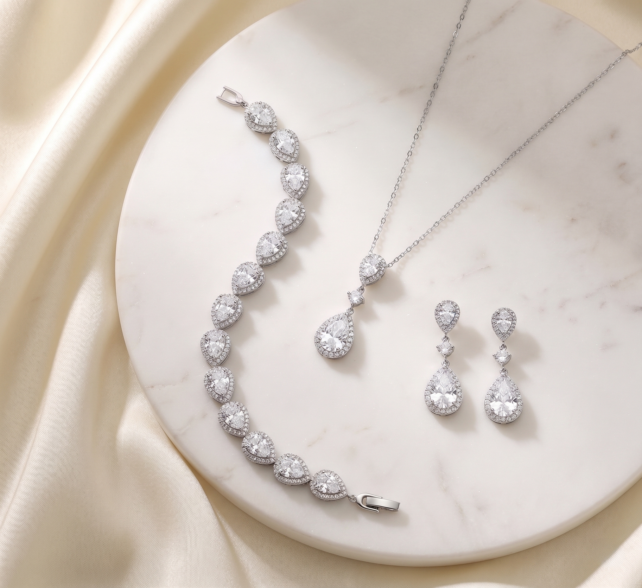 A necklace, bracelet, and earrings are displayed on a white marble surface, showcasing a collection of elegant jewelry pieces.