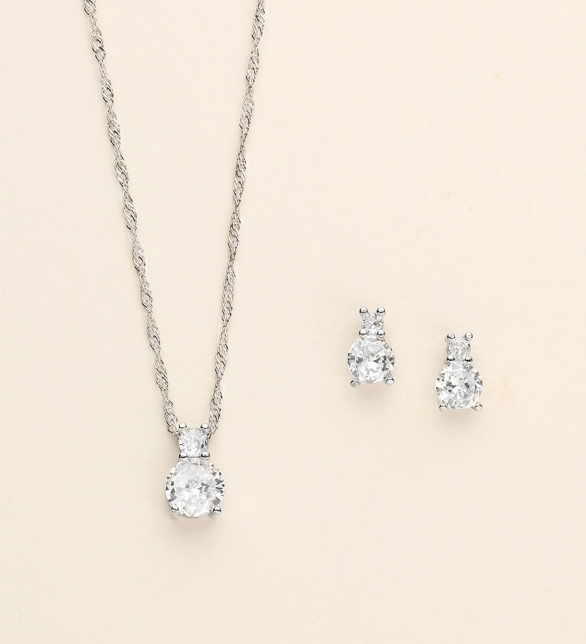 a pair of earrings and a necklace on a white background