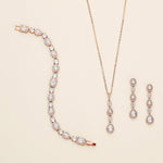 a necklace, bracelet, and earrings on a white surface