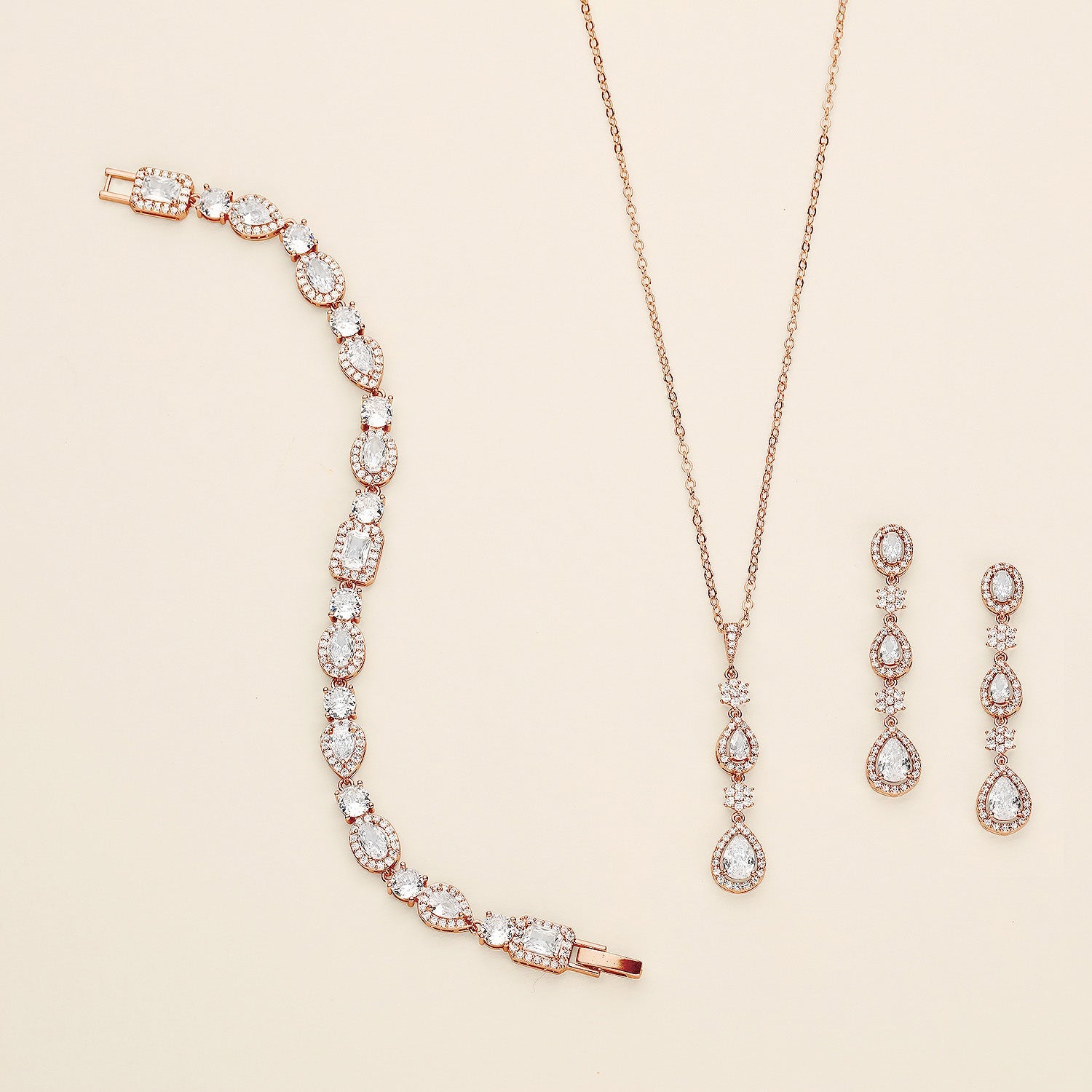 a necklace, bracelet, and earrings on a white surface