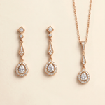 a set of elegant gold jewelry pieces, including earrings and a necklace, adorned with sparkling diamonds.