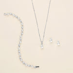 a collection of jewelry, including a necklace, earrings, and a bracelet, all featuring a combination of pearls and diamonds.