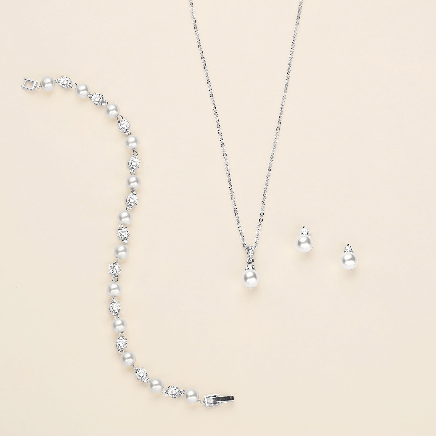a collection of jewelry, including a necklace, earrings, and a bracelet, all featuring a combination of pearls and diamonds.