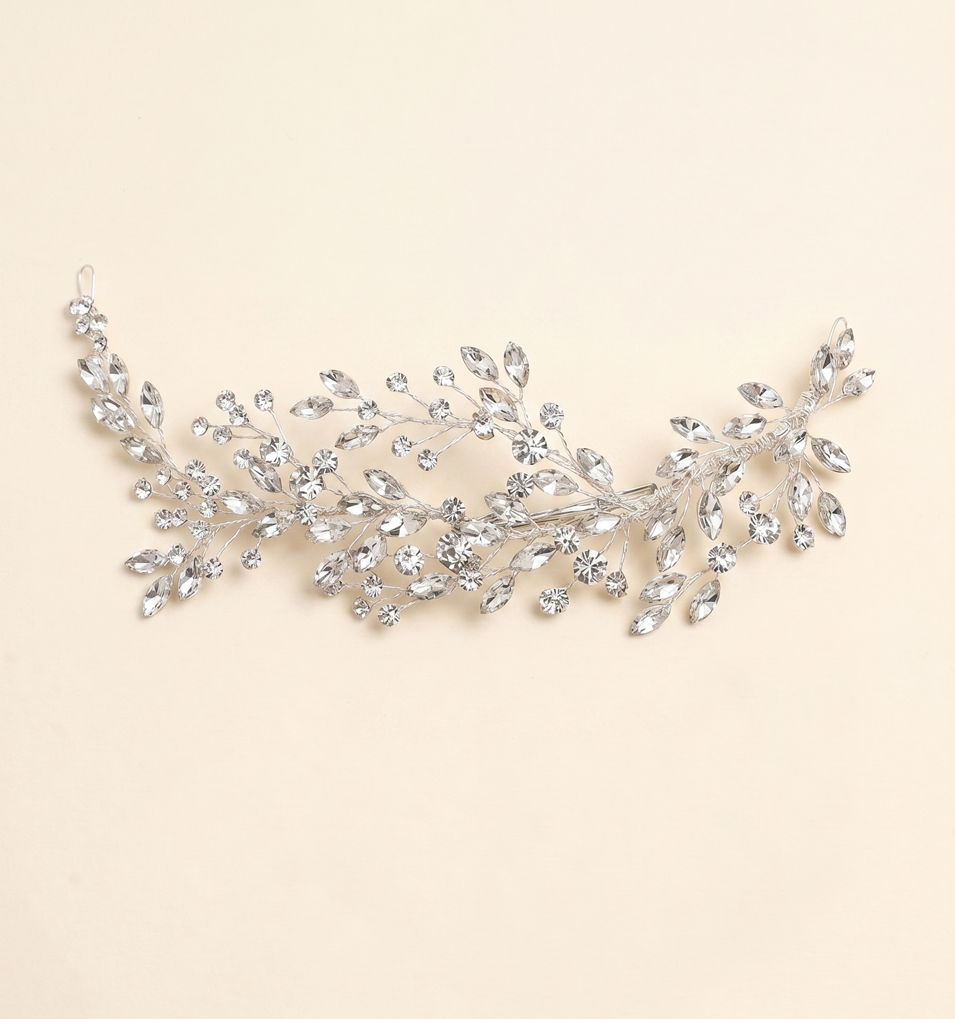 A decorative piece of jewelry with a branch-like design, adorned with numerous small, clear gemstones.