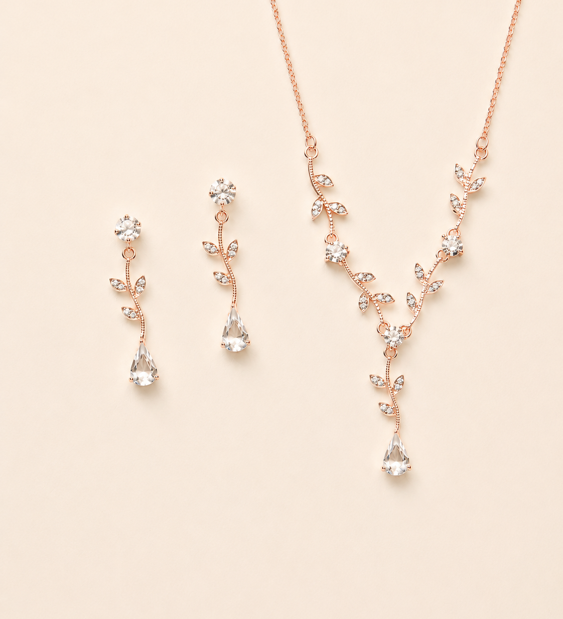 a delicate necklace and earrings set with a floral design, featuring small clear gemstones.