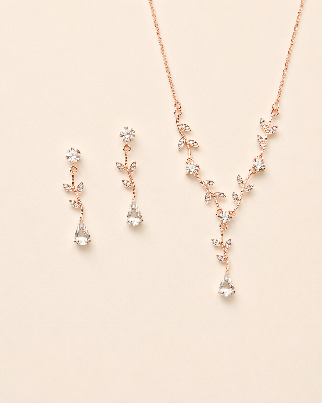 a delicate necklace and earrings set with a floral design, featuring small clear gemstones.
