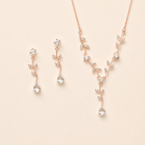 a delicate necklace and earrings set with a floral design, featuring small clear gemstones.