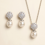 A necklace and earrings set with a combination of pearls and diamonds.