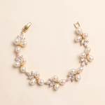 A delicate gold bracelet adorned with numerous small pearls and crystal accents.