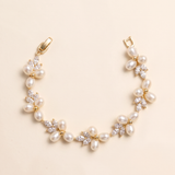 A delicate gold bracelet adorned with numerous small pearls and crystal accents.
