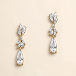 A pair of elegant gold earrings with clear gemstones, including pear-shaped and teardrop-shaped stones, hanging from the ear hooks.