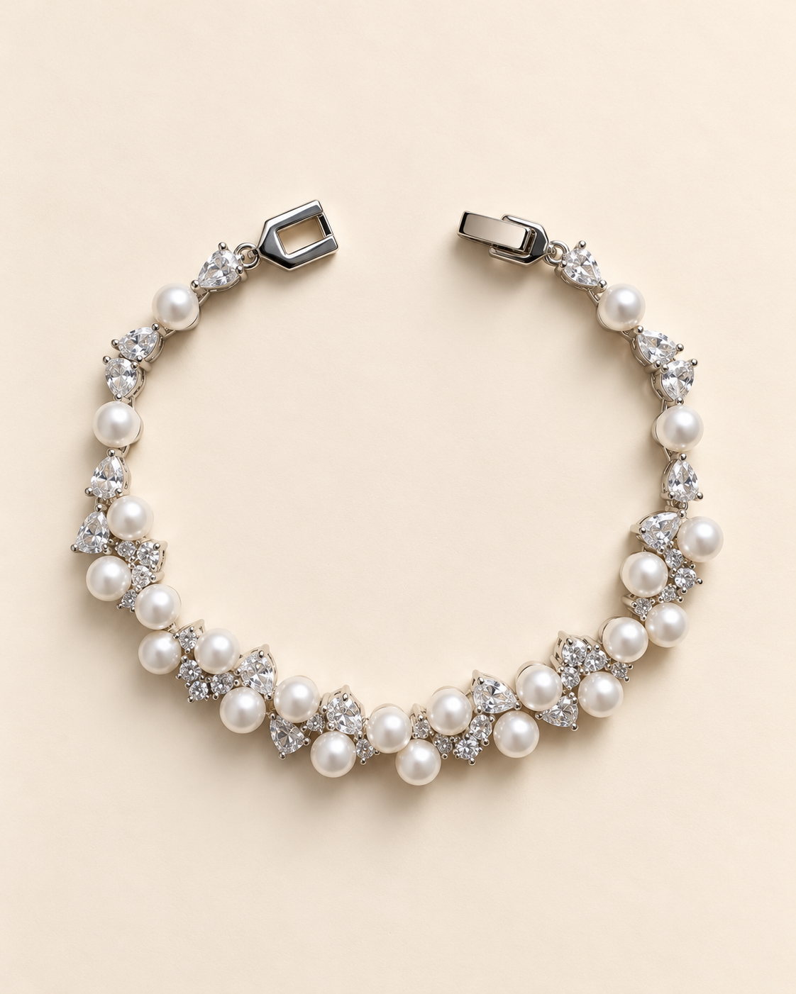 Athena silver-finish bracelet arranged in a curve, showing clustered pearl-like accents, clear faceted details and clasp
