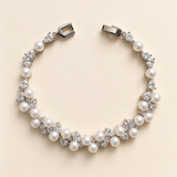 Athena silver-finish bracelet arranged in a curve, showing clustered pearl-like accents, clear faceted details and clasp