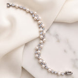 Athena silver-finish bracelet laid across cream fabric and a pale stone surface