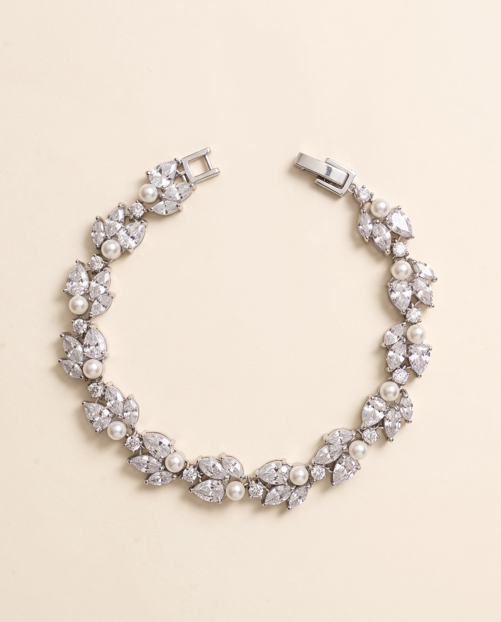 Audrey pearl and cubic zirconia bracelet in silver with leaf-inspired clusters on a cream background