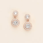 A pair of elegant gold earrings with large, clear gemstones set in a circular design.