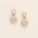 A pair of elegant gold earrings with large, clear gemstones set in a circular design.