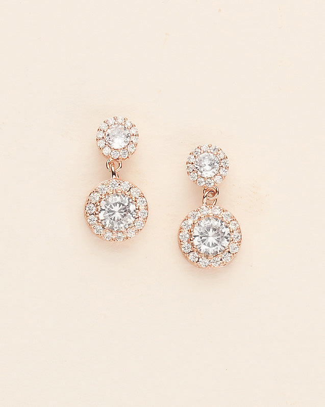 A pair of elegant gold earrings with large, clear gemstones set in a circular design.