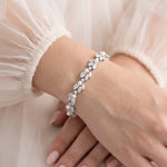 A close-up image of a person's hand wearing a bracelet with a floral design.