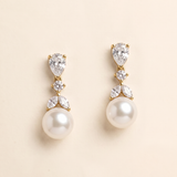 A pair of elegant gold earrings with pearls and diamonds.