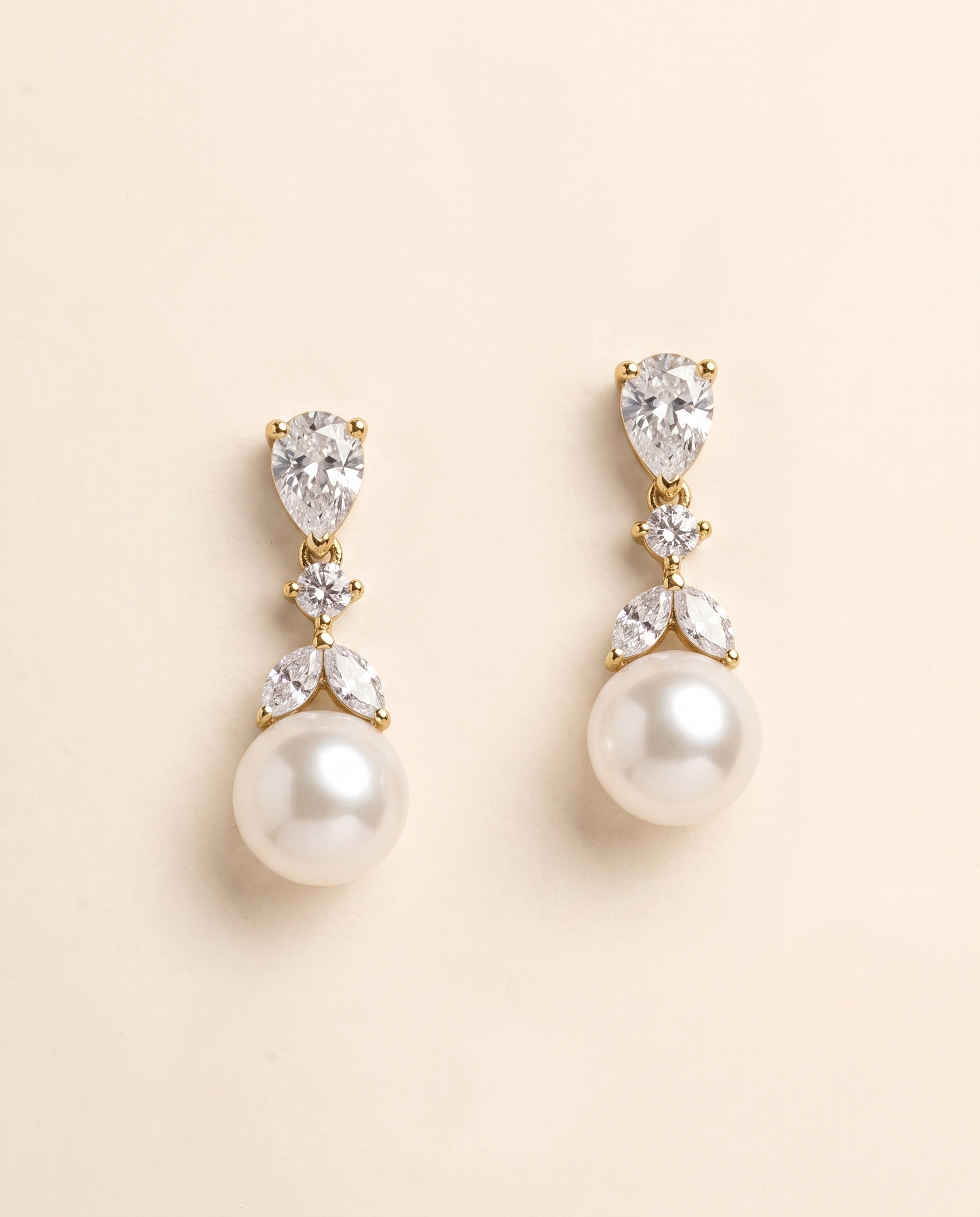 A pair of elegant gold earrings with pearls and diamonds.