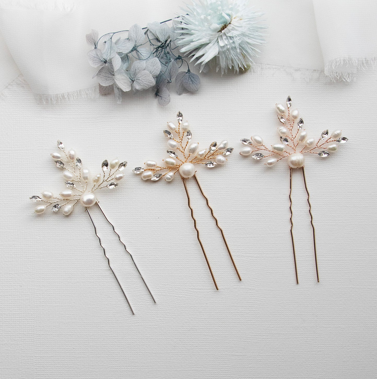 three different types of hair pins on a white surface