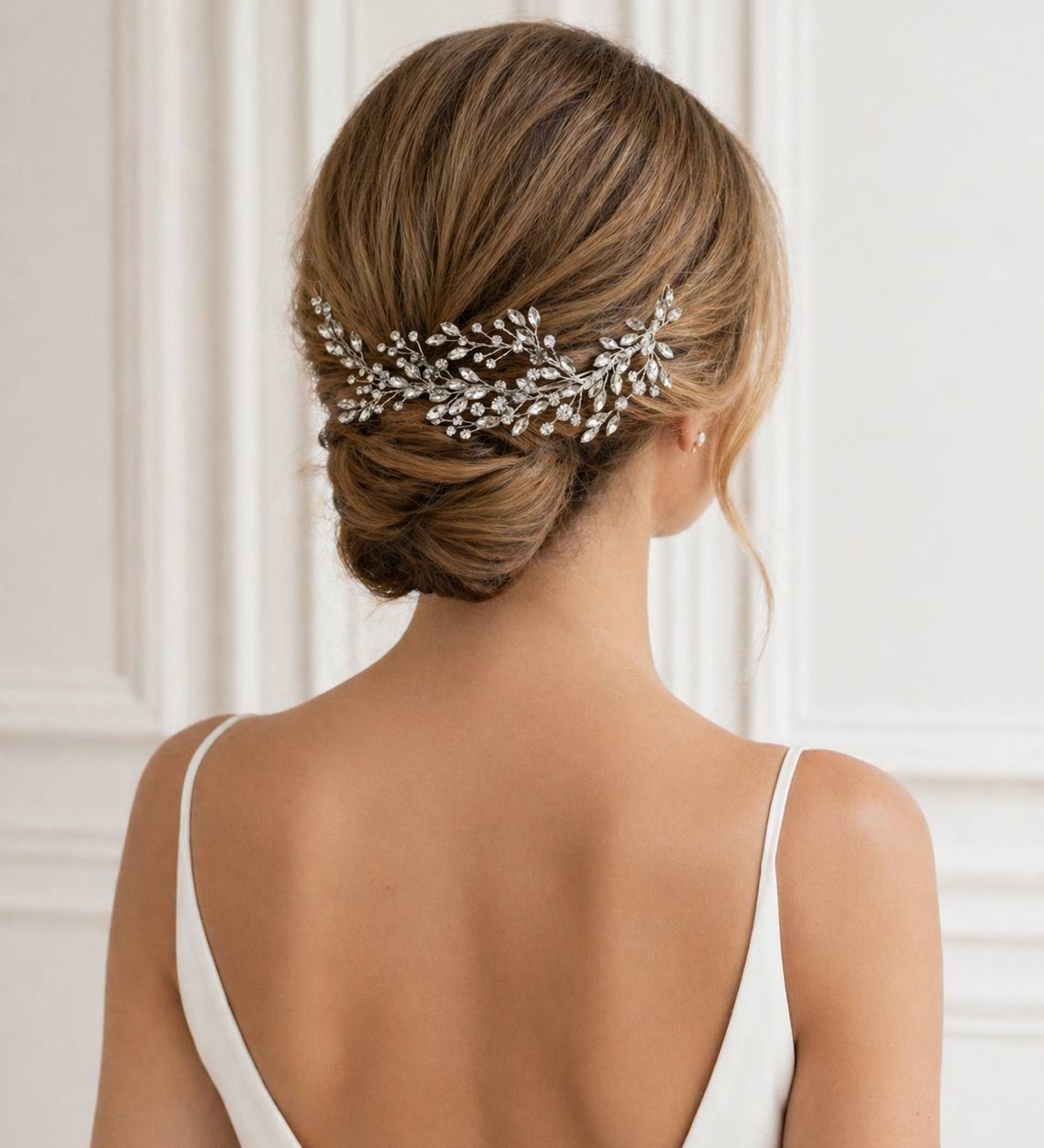 the back view of a woman's hair, with a decorative hair accessory, possibly a hairpiece or veil, pinned to her hair.