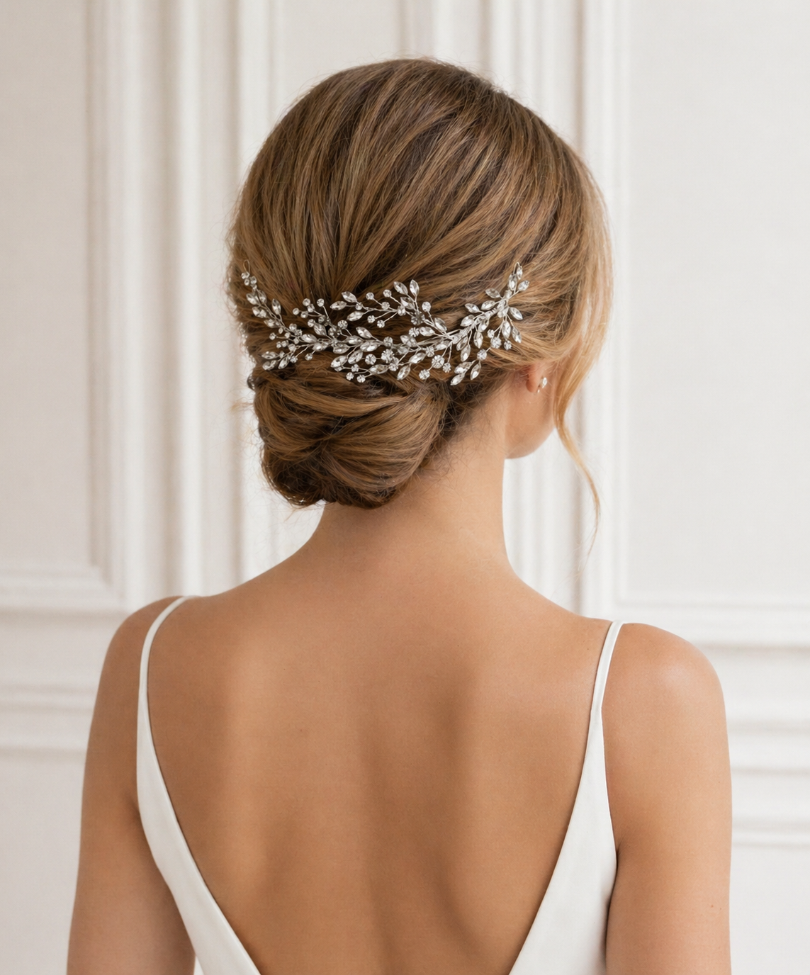 the back view of a woman's hair, with a decorative hair accessory, possibly a hairpiece or veil, pinned to her hair.