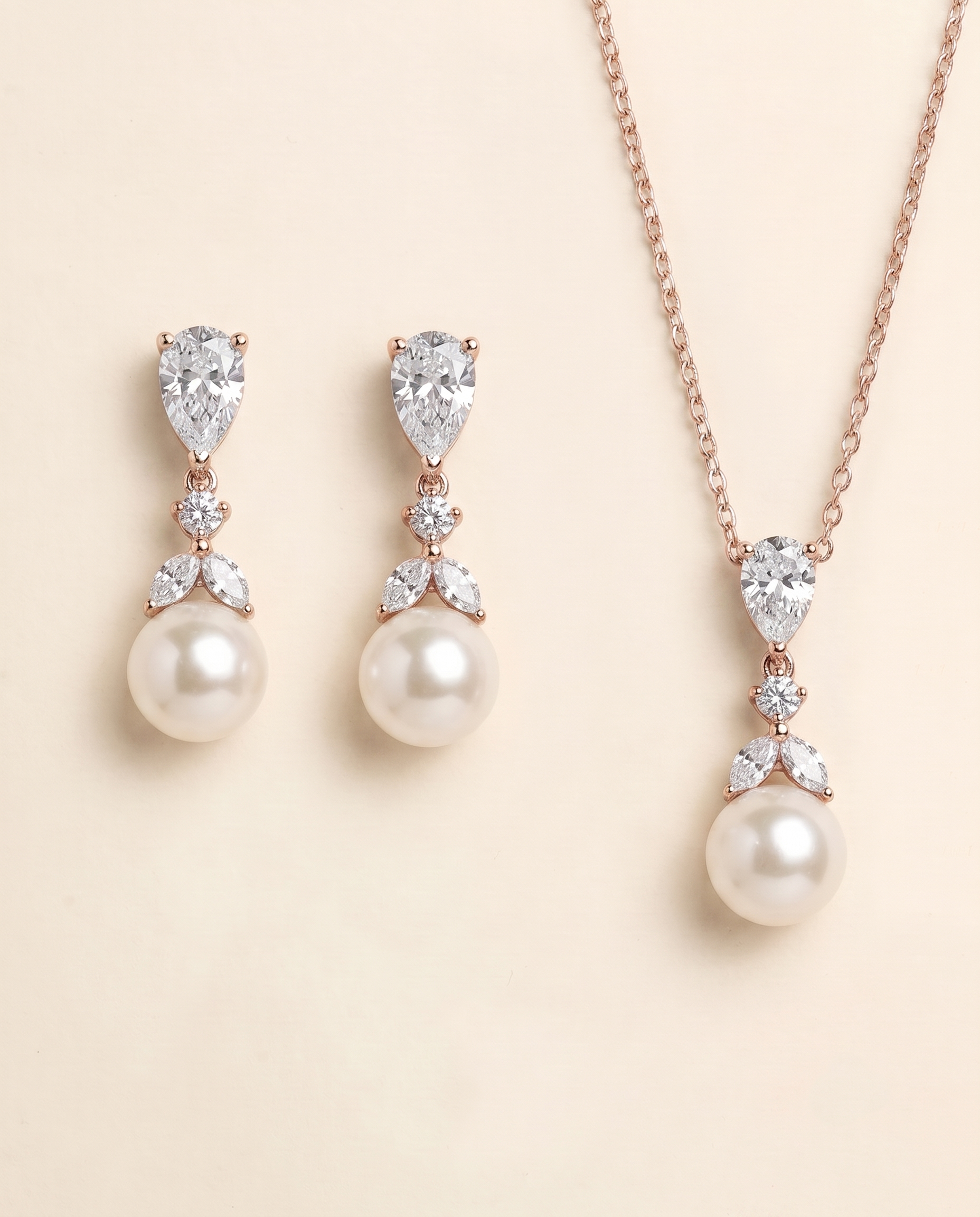 A necklace and earrings set featuring a pendant and a pearl.