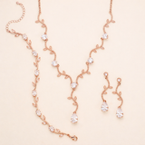 a delicate and elegant necklace and earring set, featuring a delicate chain with small, clear gemstones and a pair of dangling earrings with similar clear gemstones.