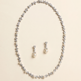 A necklace and earrings set made of silver and white pearls and diamonds.
